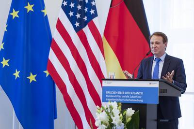 Dr. David Sirakov, Direktor der Atlantischen Akademie RLP e. V. bei seiner Rede vor der Fahne der USA und der Fahne des-stock-foto