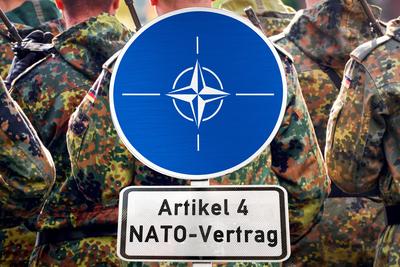 Germany - September 10, 2025: PHOTOMONTAGE, NATO sign with inscription: Article 4 NATO Treaty, in front of German soldie-stock-foto