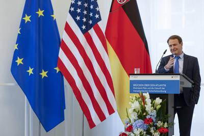 Dr. David Sirakov, Direktor der Atlantischen Akademie RLP e. V. bei seiner Rede vor der Fahne der USA und der Fahne des-stock-foto