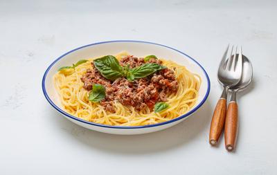 Italienische Spaghetti Bolognese mit Basilikum und Parmesan auf Teller auf wei?em Hintergrund Ansicht von oben-stock-foto