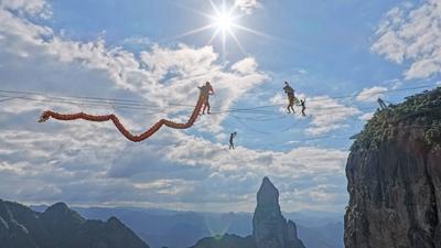 TAIZHOU, CHINA - SEPTEMBER 22: A slackline walker performs dragon dance at Shenxianju scenic area on September 22, 2025-stock-foto