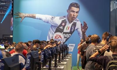 Gamescom Besucher spielen das neue FIFA19 Fussball Videospiel vor einem ?berdimensionalem Bild von C-stock-foto