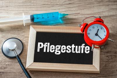 08 July 2023: Chalkboard with syringe and alarm clock with inscription: level of care. Symbol image care level of people-stock-foto