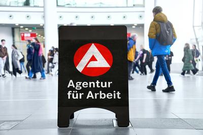 Bavaria, Germany - August 30, 2025: PHOTOMONTAGE, sign with Agentur f?r Arbeit logo in a hall, in the background many pe-stock-foto