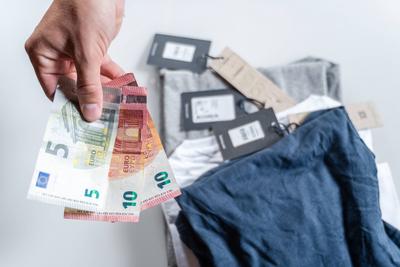 Bavaria, Germany - August 27, 2025: A customer pays for clothing in a retail store in cash with euro bills. Cash as a tr-stock-foto