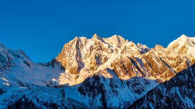 GARZE, CHINA - DECEMBER 01: Golden sun rays shine over Mount Gongga on December 1, 2024 in Garze Tibetan Autonomous Pref-stock-foto