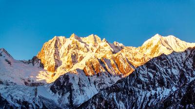 GARZE, CHINA - DECEMBER 01: Golden sun rays shine over Mount Gongga on December 1, 2024 in Garze Tibetan Autonomous Pref-stock-foto