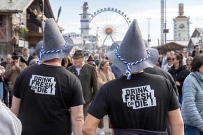 Oktoberfest im Sonnenschein, Wiesnbesucher genie?en den sonnigen Herbsttag auf der Theresienwiese, Touristen mit Wiesnh?tn, M?nchen, Oktober 2025-stock-foto