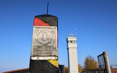 Grenzstein mit der Aufschrift Deutsche Demokratische Republik und ein Grenzwachturm auf dem Gelaende des Grenzmuseums Sc-stock-foto