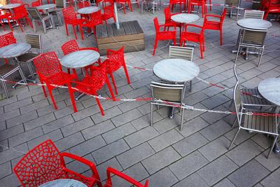 Leere rote St?hle und leere Tische vor einem Cafe - Cafe ohne Besucher - Eisdiele ohne Besucher - Corona-Krise - Virus --stock-foto