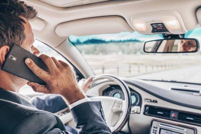 Man using cell phone while driving Businessman talking on cell phone while driving and overtaking, not paying attention-stock-foto