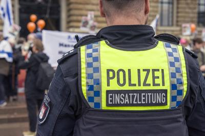 Polizeibeamter der Einsatzleitung beobachtet eine Demonstration in der Innenstadt-stock-foto