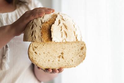 Sourdough bread hold in hands. No yeast bread Unrecognizable woman holding sourdough bread, homemade with wheat flour an-stock-foto