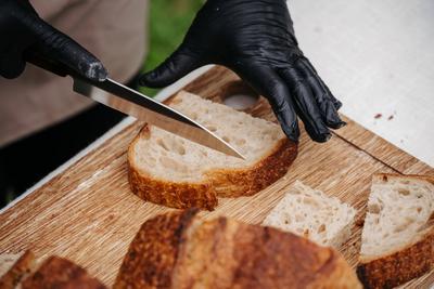 Cook cutting rustic sourdough bread on cutting board.-stock-foto
