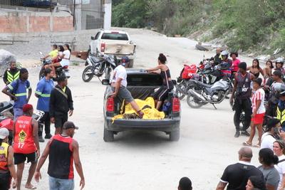 Residents recover bodies in the woods after a major operation in the Alemao and Penha favela complexes.-stock-foto