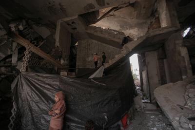 Palestinian families are living amid the ruins of residential towers destroyed by Israeli airstrikes.-stock-foto