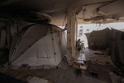 Palestinian families are living amid the ruins of residential towers destroyed by Israeli airstrikes.-stock-foto