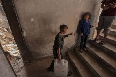 Palestinian families are living amid the ruins of residential towers destroyed by Israeli airstrikes.-stock-foto