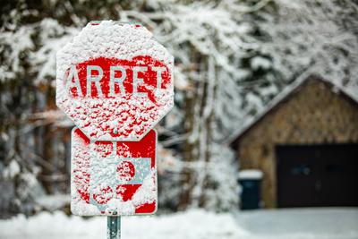 Road warning sign after snow storm A selective focus shot of a French Canadian traffic control sign saying stop, covered-stock-foto