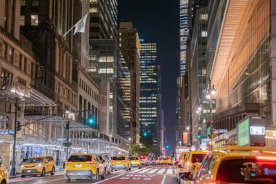 Nachtansicht von Midtown Manhattan mit gelben Taxis und Wolkenkratzern-stock-foto
