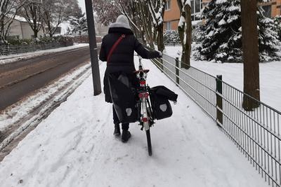 Frau mit Fahrrad auf einem verschneiten Gehweg Hamburg Hamburg Deutschland *** Woman with bicycle on a snowy sidewalk Ha-stock-foto