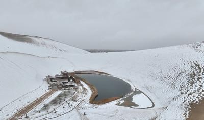 DUNHUANG, CHINA - NOVEMBER 23: A view of the scenery of the Mingsha Mountain and Crescent Spring Scenic Area after a sno-stock-foto