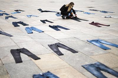 A demonstrator puts a pair of jeans on the ground during a flash mob for the Denim Day and against gender violence organ-stock-foto