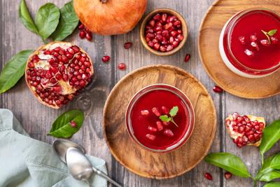 Winter delicious italian dessert panna cotta with pomegranate jelly and mint, homemade cuisine on a wooden background. V-stock-foto
