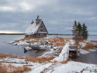 Verschneite Winterlandschaft mit authentischem Filmhaus am Ufer im russischen Dorf Rabocheostrovsk.-stock-foto
