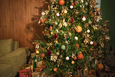 Frohe Weihnachten Xmas gl?ckliche Feiertage. Goldenes Ornament Dekoration Ball und defokussiert Girlande Lichter auf klassische geschm?ckten Weihnachtsbaum. Weihnachtsbaum mit braunen Ornamenten. Heiligabend zu Hause.-stock-foto