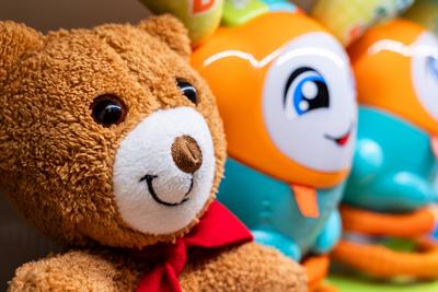 Weicher Teddyb?r mit buntem Spielzeug f?r Kinder. Konzept der Komfort, Freude und eine spielerische Kindheit Atmosph?re-stock-foto