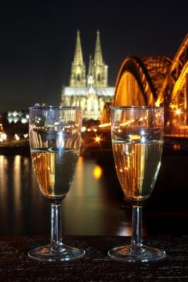 Silvester in K?ln zwei Gl?ser mit Sekt stehen am Deutzer Ufer vor der Hohenzollernbr?cke und dem K?-stock-foto