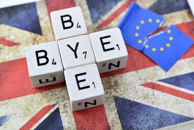 W?rfelbuchstaben formen den Schriftzug Bye-bye auf der Fahne von Gro?britannien neben einer zerrissenen EU-Fahne *** Di-stock-foto