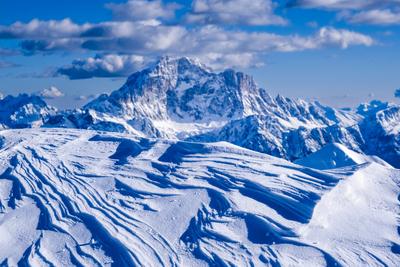 Snowdrift below the summit of Mt. Lagazuoi in winter, snow-covered summit of Monte Civetta blurred in the distance. Cort-stock-foto