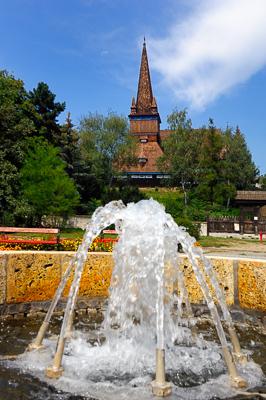 Miskolc, szökőkút a Petőfi téren (háttérben a Deszkatemplom)-stock-photo