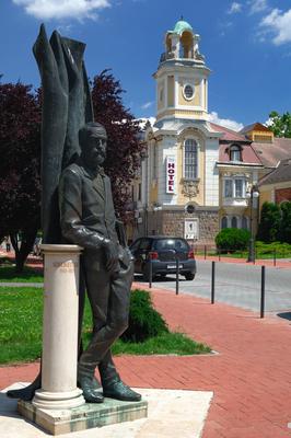 A Tisza Szálló és Gyógyfürdő, előtérben Szigligeti Ede szobra, Szolnok, Verseghy park-stock-foto