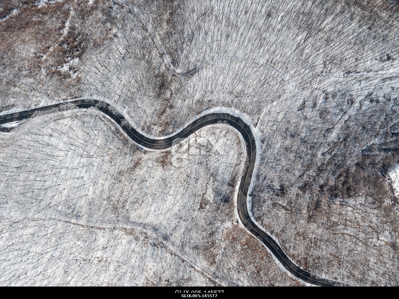 Aerial view of curvy road in Mecsek forest st winter.Erdei út a Mecsekben Pécs környékén télen, madártávlatból.