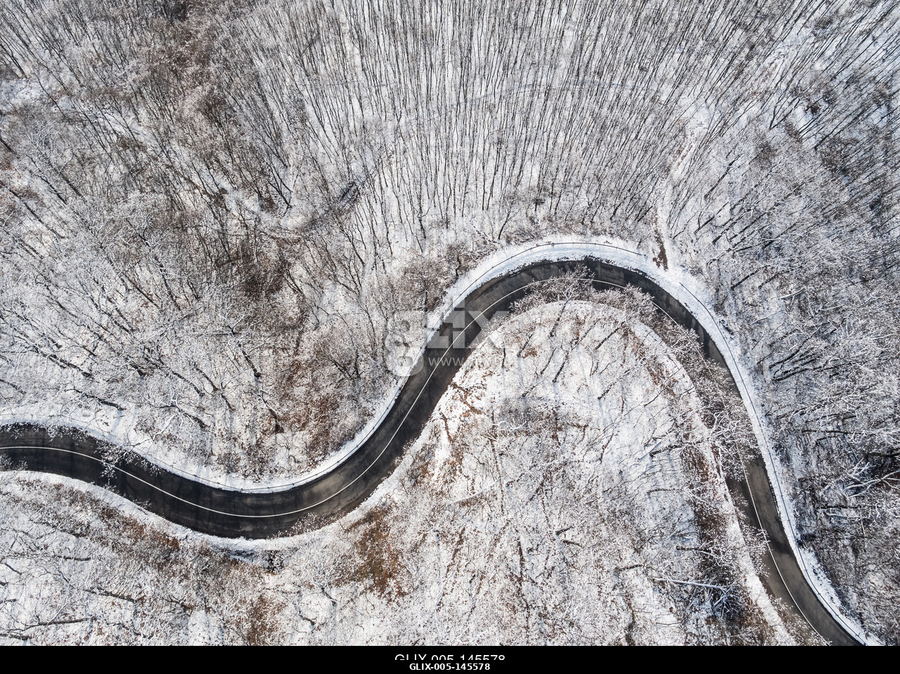 Aerial view of curvy road in Mecsek forest st winter.Erdei út a Mecsekben Pécs környékén télen, madártávlatból.