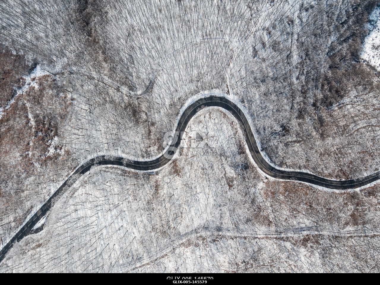 Aerial view of curvy road in Mecsek forest st winter.Erdei út a Mecsekben Pécs környékén télen, madártávlatból.