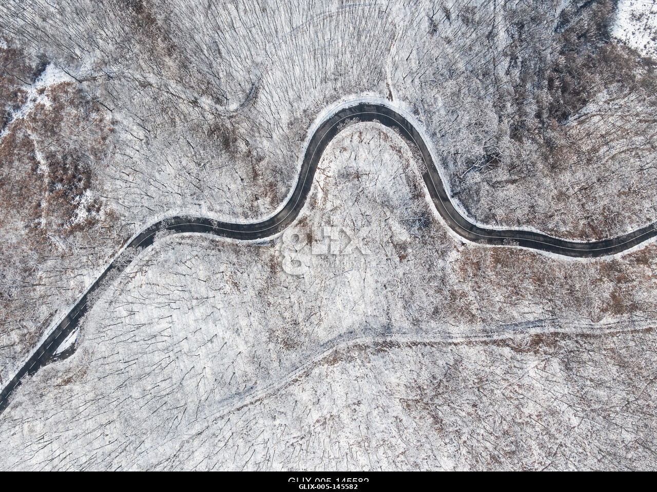Aerial view of curvy road in Mecsek forest st winter.Erdei út a Mecsekben Pécs környékén télen, madártávlatból.