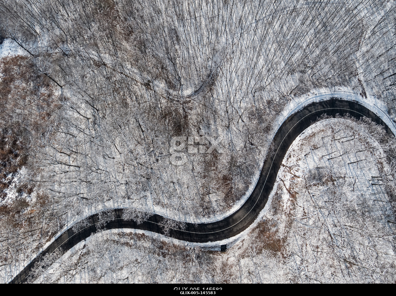 Aerial view of curvy road in Mecsek forest st winter.Erdei út a Mecsekben Pécs környékén télen, madártávlatból.