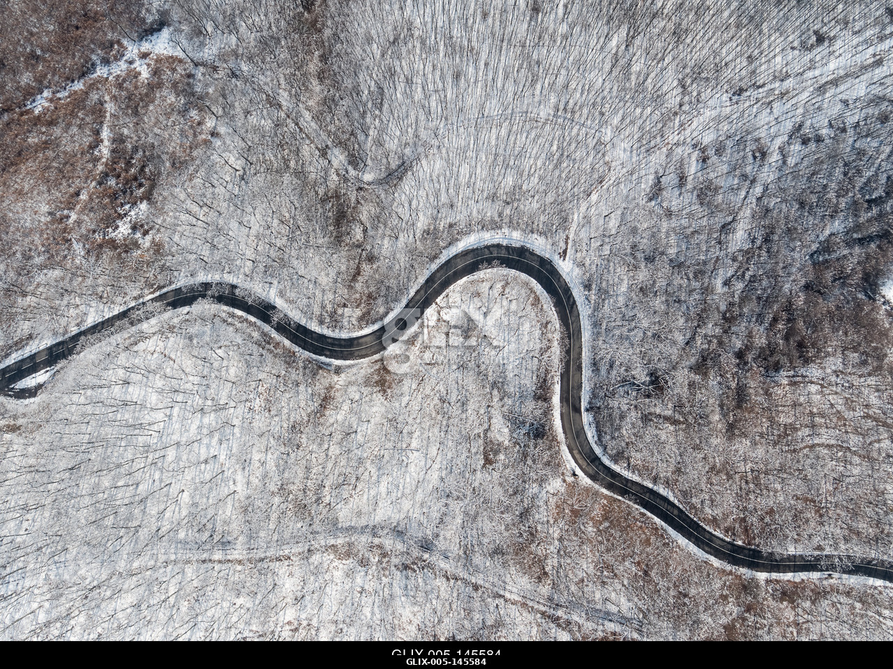 Aerial view of curvy road in Mecsek forest st winter.Erdei út a Mecsekben Pécs környékén télen, madártávlatból.