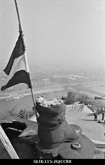 BUDAPEST 1956 Egy magyar zászló, középen a szovjet címer nélkül, egy bakancsra erősítve. Ez minden, ami egy szovjet katonát ábrázoló óriási szoborb...