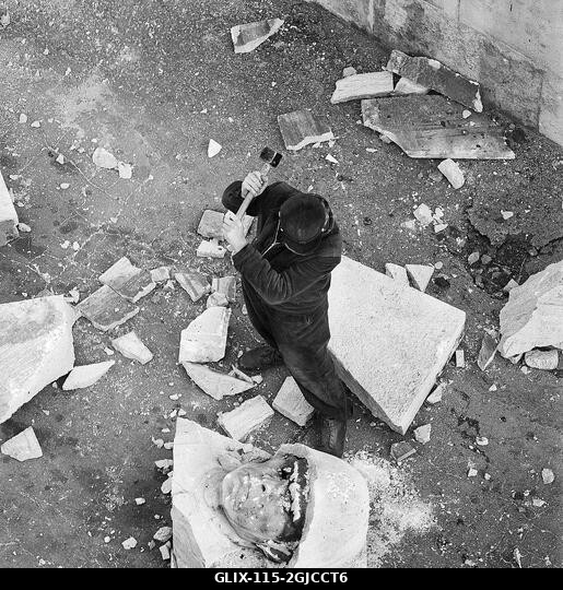BUDAPEST 1956 Egy szovjet katonát ábrázoló óriási szoborhoz tartozó, betonba süllyesztett katonafejet egy kalapáccsal szilánkokra kalapálnak, miutá...