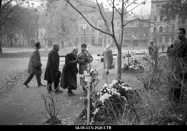 BUDAPEST 1956 Emberek gyászolnak rögtönzött síroknál egy központi budapesti utcában a Magyar Népköztársaság és a szovjetek által kényszerített poli...