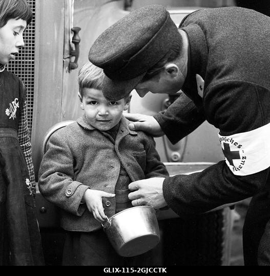 BUDAPEST 1956 Egy Német Vöröskereszt-tag segít egy kisfiúnak Budapesten, a Magyar Népköztársaság és a szovjetek által kényszerített politika elleni...