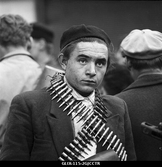 BUDAPEST 1956 Fegyveres magyar felkelő töltényövvel a kezében Budapesten, Magyarországon, a Magyar Népköztársaság és a szovjetek által kényszerítet...