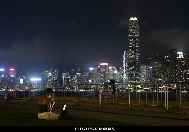 LEGJOBB KÉPEK - Egy személy egy füves területen ül egy korlát közelében, és Hongkong kivilágított látképére néz éjszaka, 2026. szeptember 29-én, Ho...