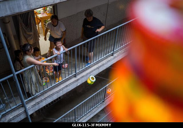 LEGJOBB KÉPEK - Lakosok osztogatnak lámpásokat egy lakótelep erkélyéről 2026. szeptember 25-én, Hongkongban. (Fotó: Vernon Yuen/Nexpher Images)