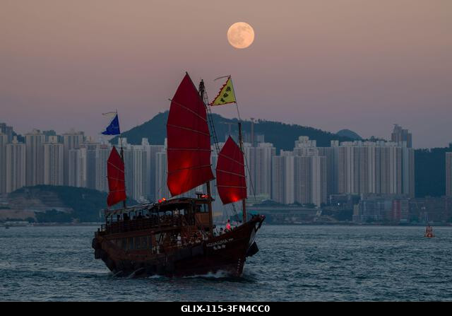 LEGJOBB KÉPEK - Egy roncshajó vitorlázik a Victoria kikötőben, holdkelte 2026. szeptember 26-án Hongkongban. (Fotó: Vernon Yuen/Nexpher Images)